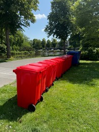 Photo of Many color trash bins on green grass in park