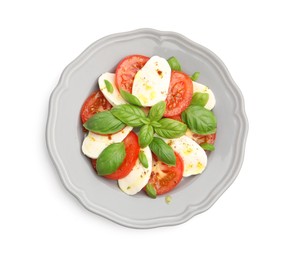 Photo of Tasty salad Caprese with mozzarella, tomatoes, basil and spices isolated on white, top view