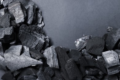 Photo of Pieces of black coals on grey background, top view. Space for text