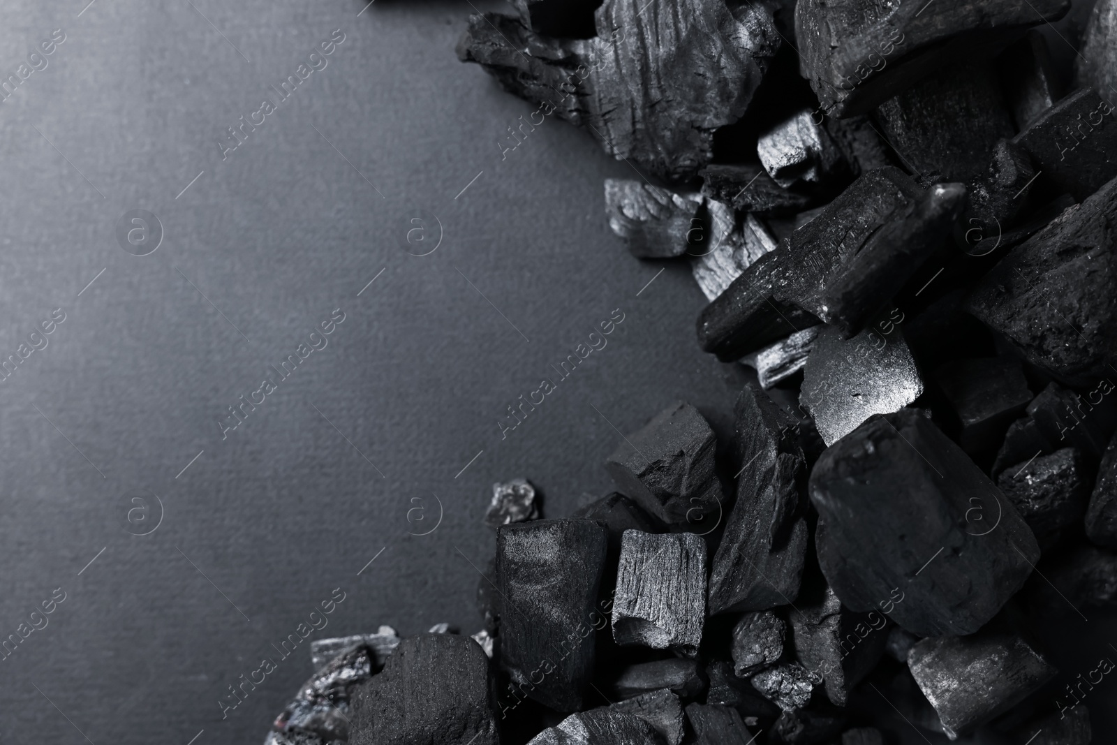 Photo of Pieces of black coals on grey background, top view. Space for text