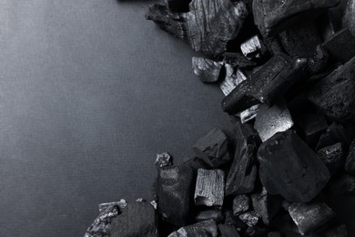 Photo of Pieces of black coals on grey background, top view. Space for text