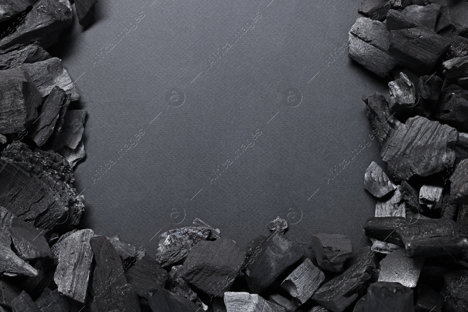 Photo of Pieces of black coals on grey background, top view. Space for text