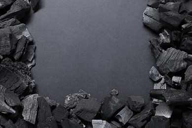 Photo of Pieces of black coals on grey background, top view. Space for text