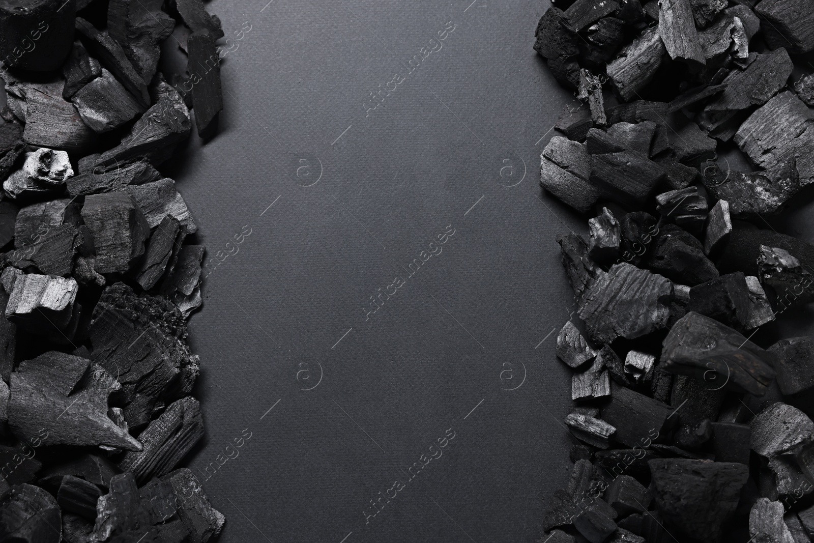 Photo of Pieces of black coals on grey background, top view. Space for text