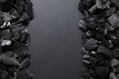 Photo of Pieces of black coals on grey background, top view. Space for text