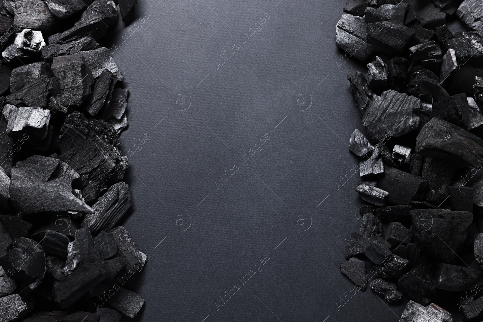 Photo of Pieces of black coals on grey background, top view. Space for text