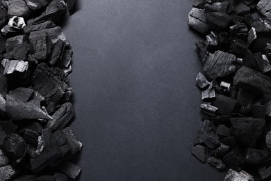 Photo of Pieces of black coals on grey background, top view. Space for text