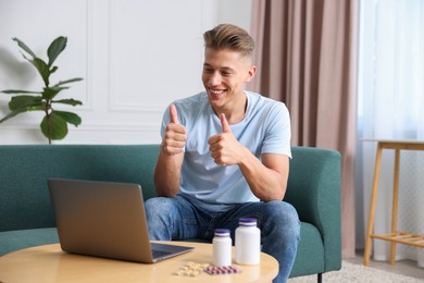 Photo of Man showing thumbs up while having online consultation with doctor via laptop at home