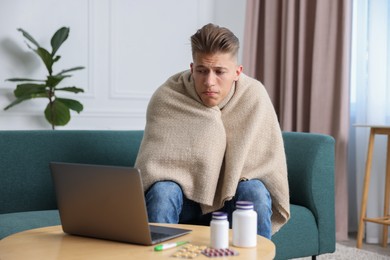 Photo of Sick man having online consultation with doctor via laptop at home