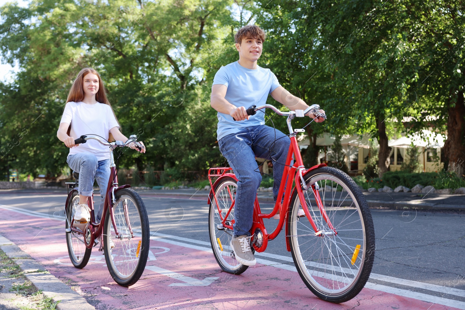 Photo of Teenage girl and boy riding bicycles on city street