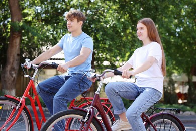 Photo of Teenage girl and boy riding bicycles on city street