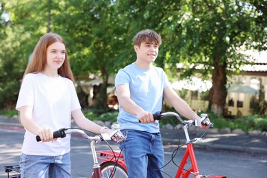 Photo of Teenage girl and boy riding bicycles on city street
