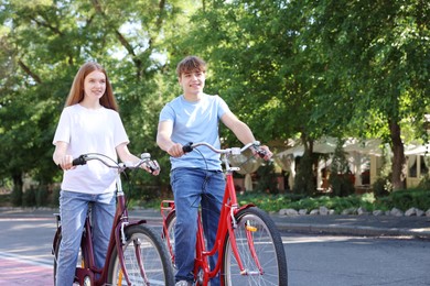 Photo of Teenage girl and boy riding bicycles on city street