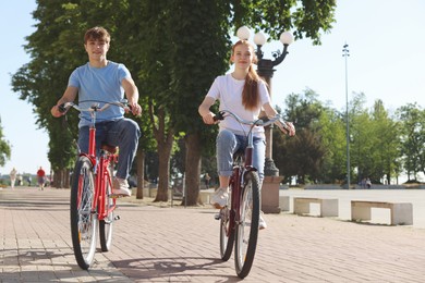 Photo of Teenage girl and boy riding bicycles on city street