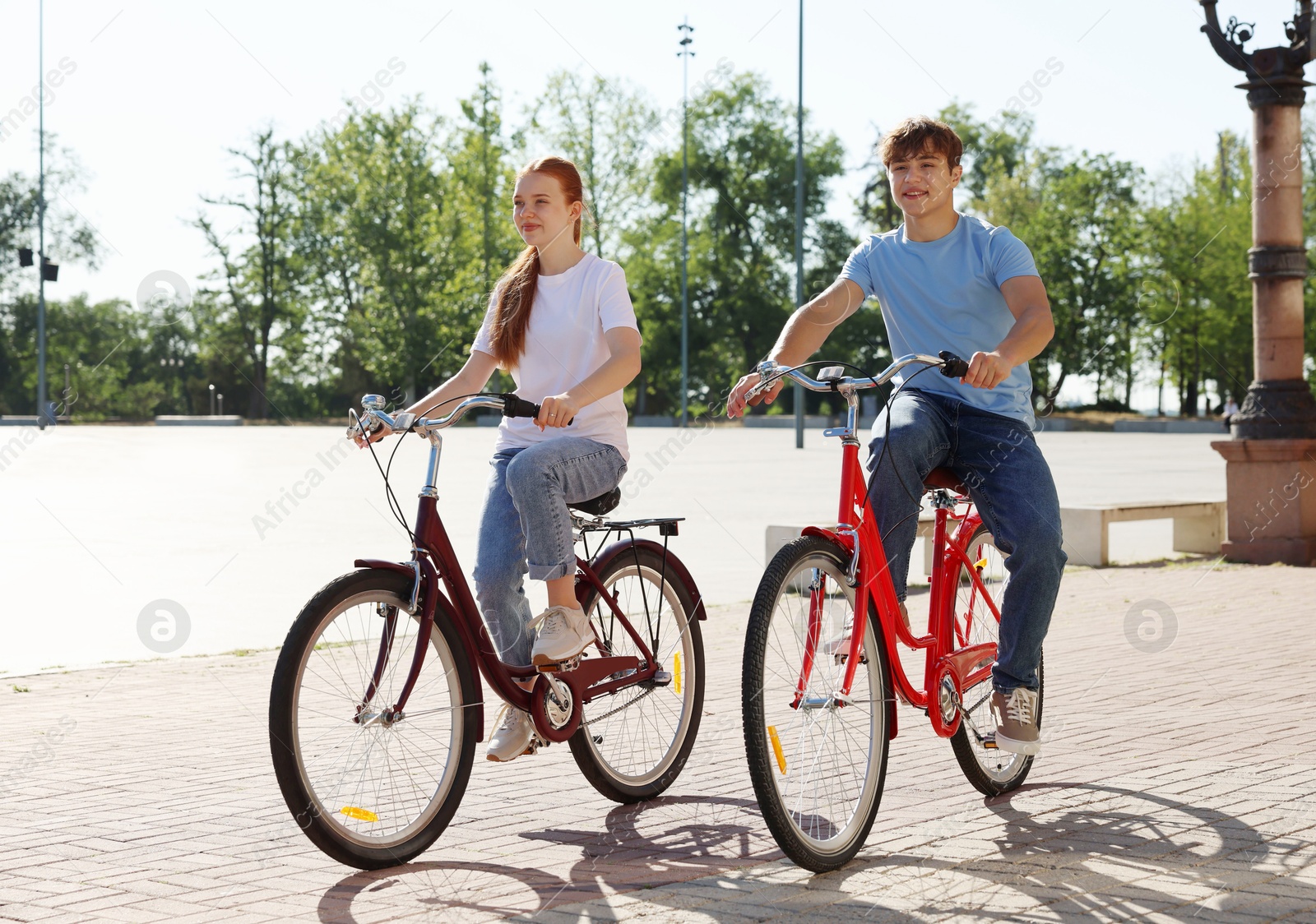 Photo of Teenage girl and boy riding bicycles on city street