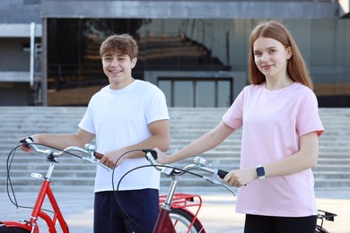 Photo of Teenage girl and boy with bicycles on city street