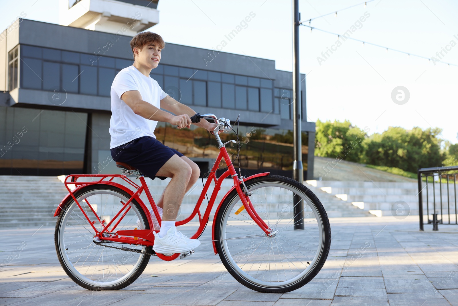 Photo of Teenage boy riding bicycle on city street