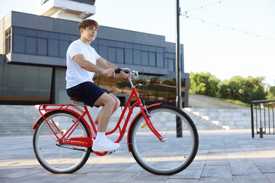 Photo of Teenage boy riding bicycle on city street