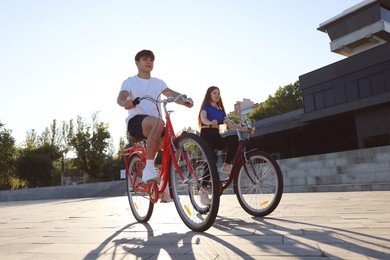 Photo of Teenage girl and boy riding bicycles on city street