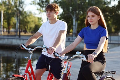 Photo of Teenage girl and boy riding bicycles on city street