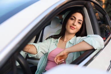 Photo of Woman holding steering wheel while driving car, view from outside
