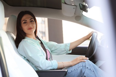 Photo of Woman holding steering wheel while driving car, view from outside