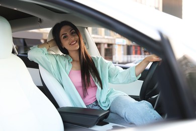 Photo of Woman sitting in modern car, view from outside