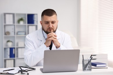 Photo of Doctor having online consultation via laptop in clinic
