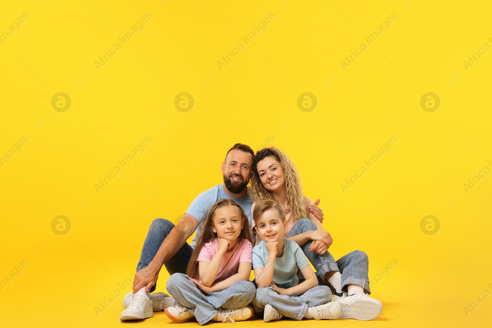Photo of Happy family on yellow background. Space for text