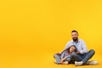 Photo of Family. Happy father and his daughter on yellow background. Space for text