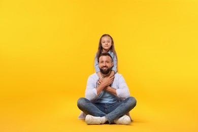 Photo of Family. Happy father and his daughter on yellow background