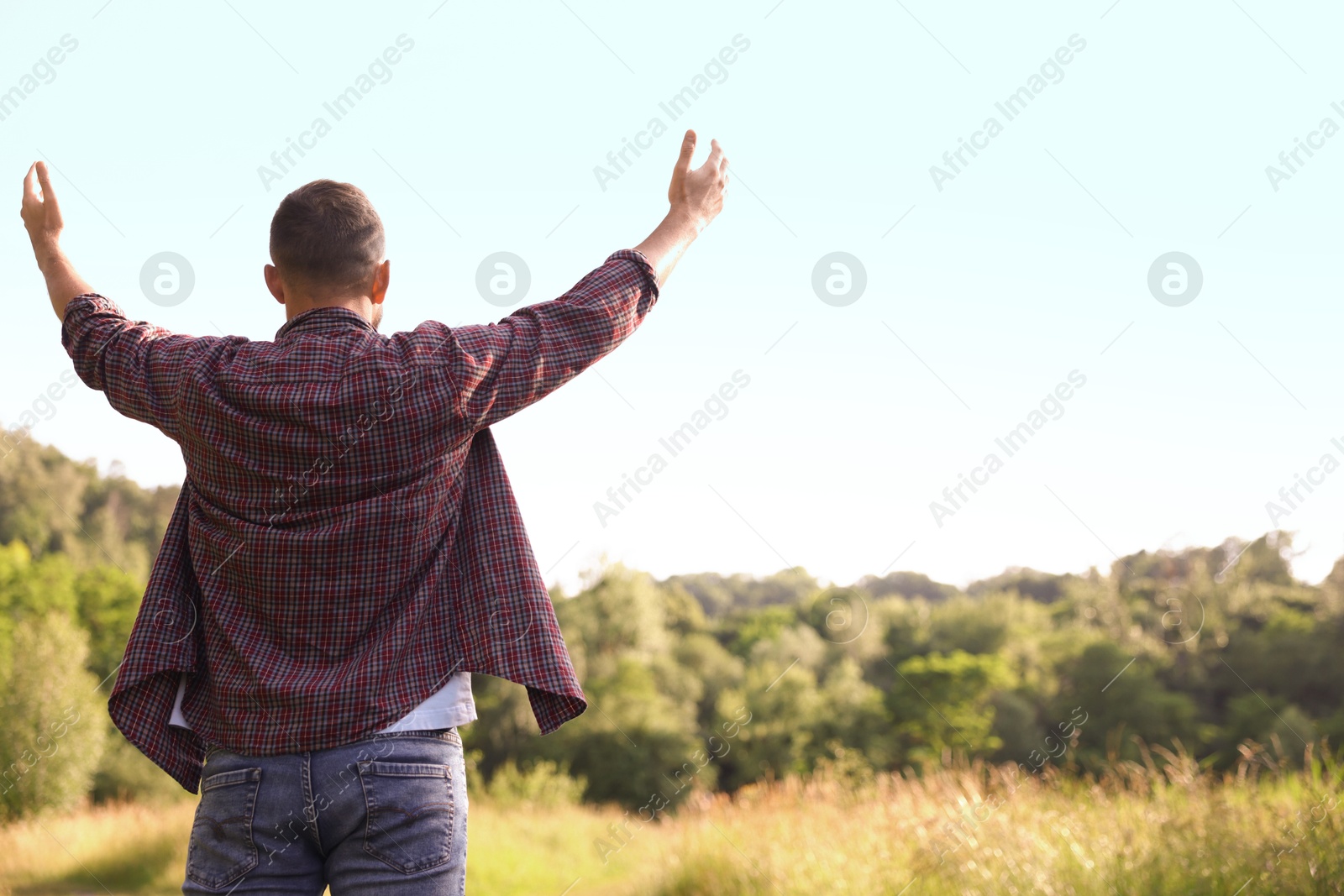 Photo of Feeling freedom. Man enjoying time outdoors, back view. Space for text