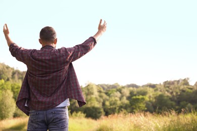 Photo of Feeling freedom. Man enjoying time outdoors, back view. Space for text