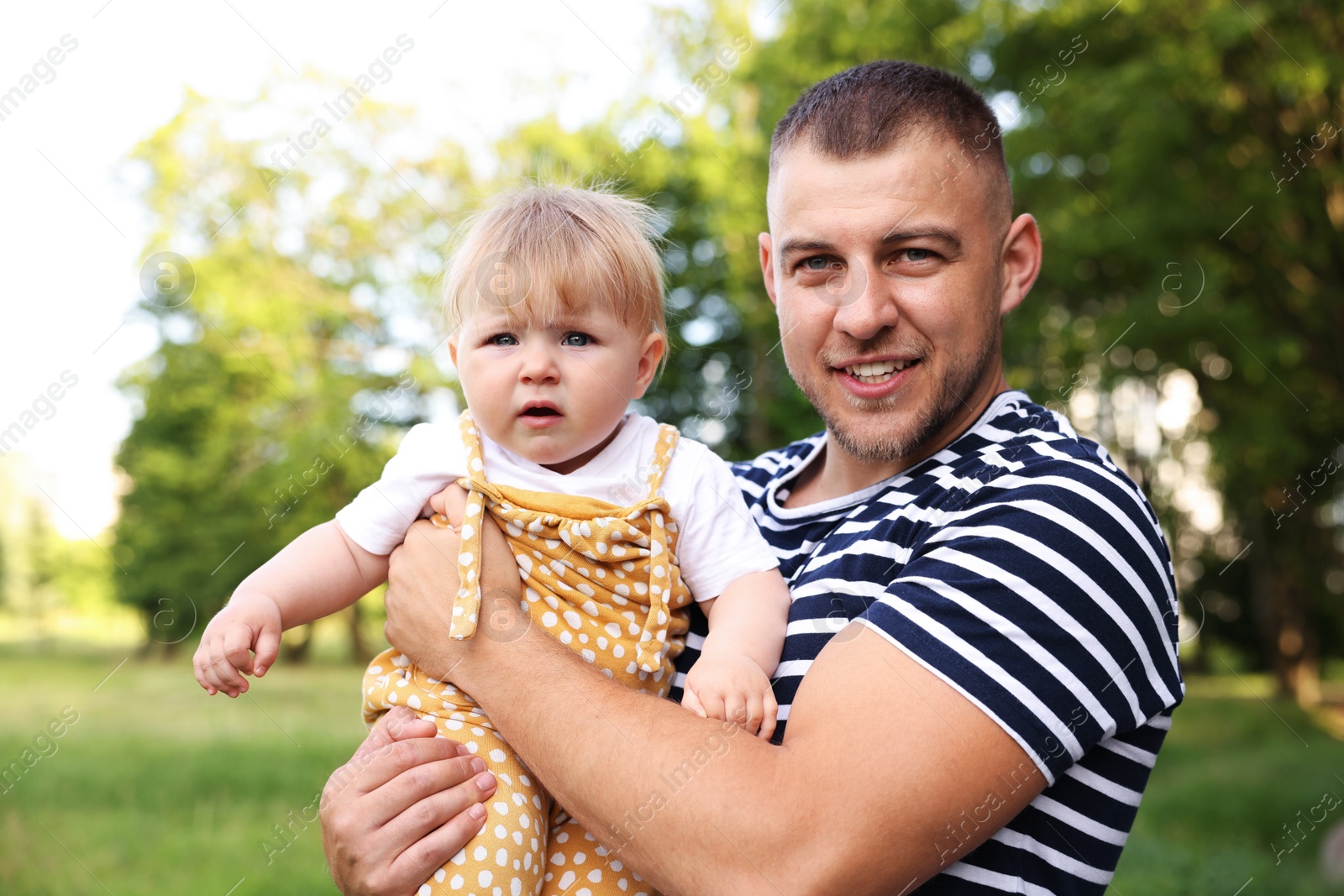 Photo of Smiling dad and his newborn baby outdoors. Happy Father's Day