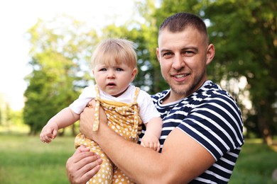 Photo of Smiling dad and his newborn baby outdoors. Happy Father's Day