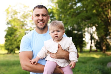 Photo of Smiling dad and his newborn baby outdoors. Happy Father's Day
