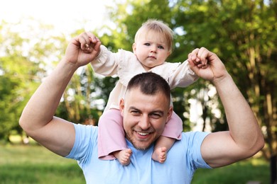 Photo of Smiling dad and his newborn baby playing outdoors. Happy Father's Day
