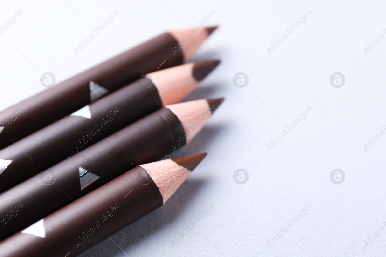 Many eyebrow pencils on white background, closeup. Space for text Photo of Many eyebrow pencils on white background, closeup. Space for text