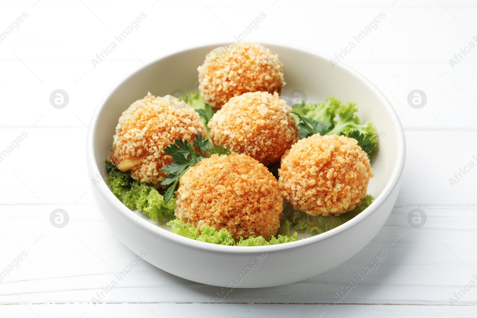Delicious fried croquette balls with parsley and lettuce on white wooden table, closeup Photo of Delicious fried croquette balls with parsley and lettuce on white wooden table, closeup