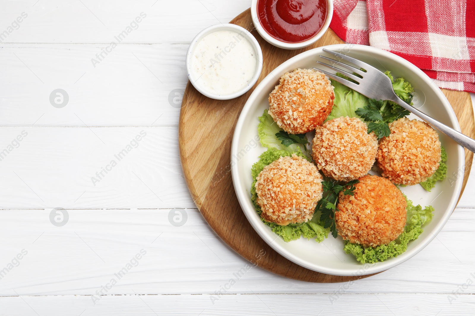 Delicious fried croquette balls with parsley, lettuce and sauces on white wooden table, top view. Space for text Photo of Delicious fried croquette balls with parsley, lettuce and sauces on white wooden table, top view. Space for text