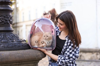 Photo of Woman with her cute cat in backpack carrier on city street