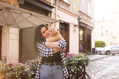 Photo of Woman with her cute cat outdoors on sunny day
