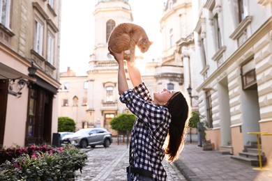 Photo of Woman with her cute cat outdoors on sunny day