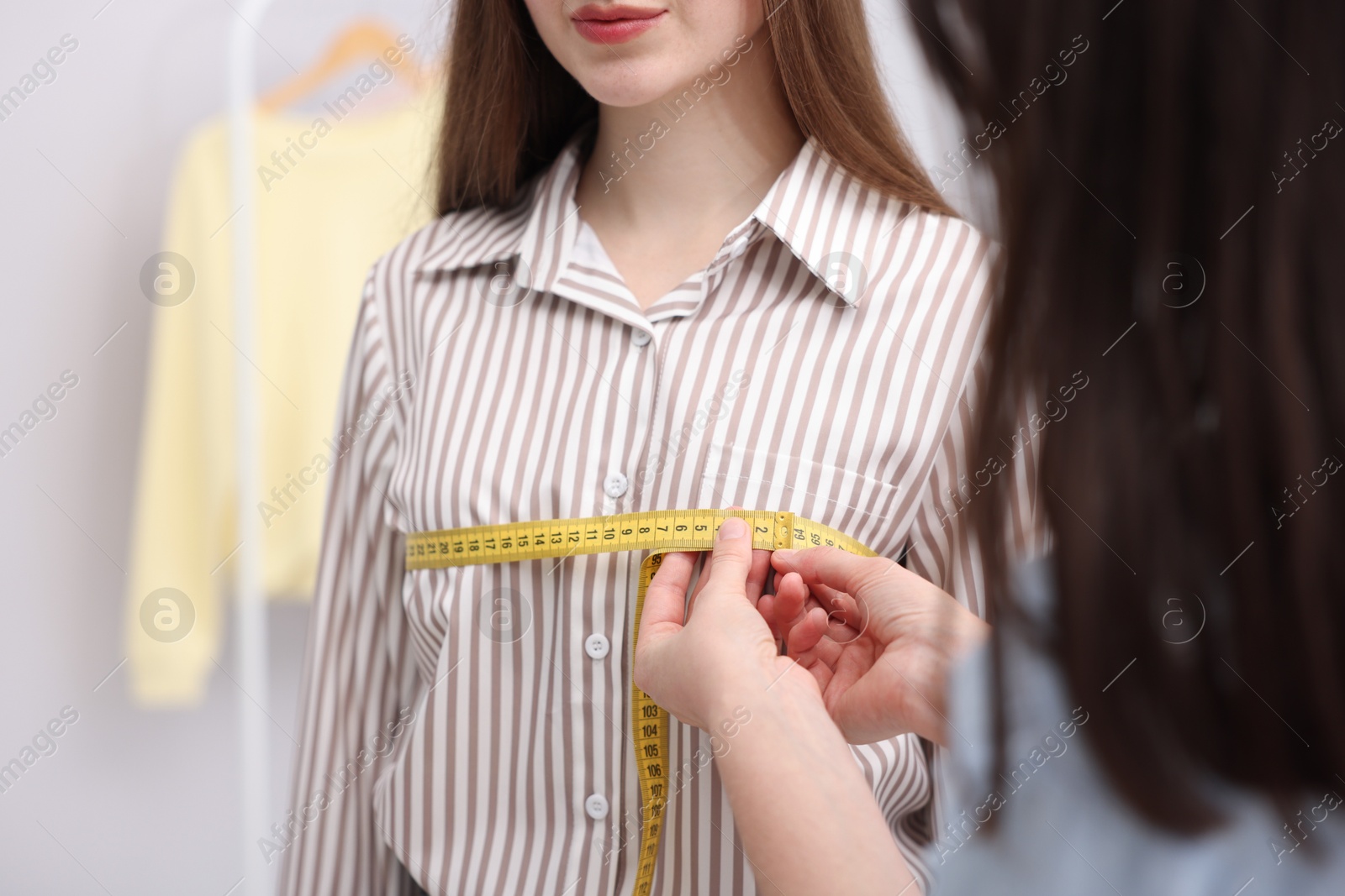 Tailor measuring woman's chest with tape in atelier, closeup Photo of Tailor measuring woman's chest with tape in atelier, closeup