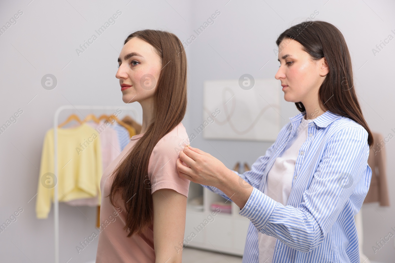 Photo of Tailor measuring woman's back with tape in atelier