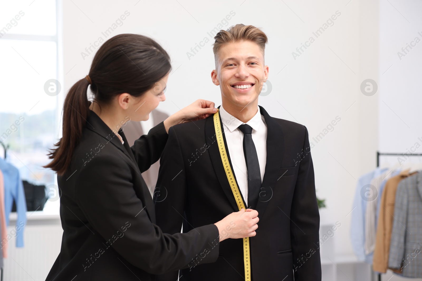Tailor measuring jacket on man in atelier Photo of Tailor measuring jacket on man in atelier