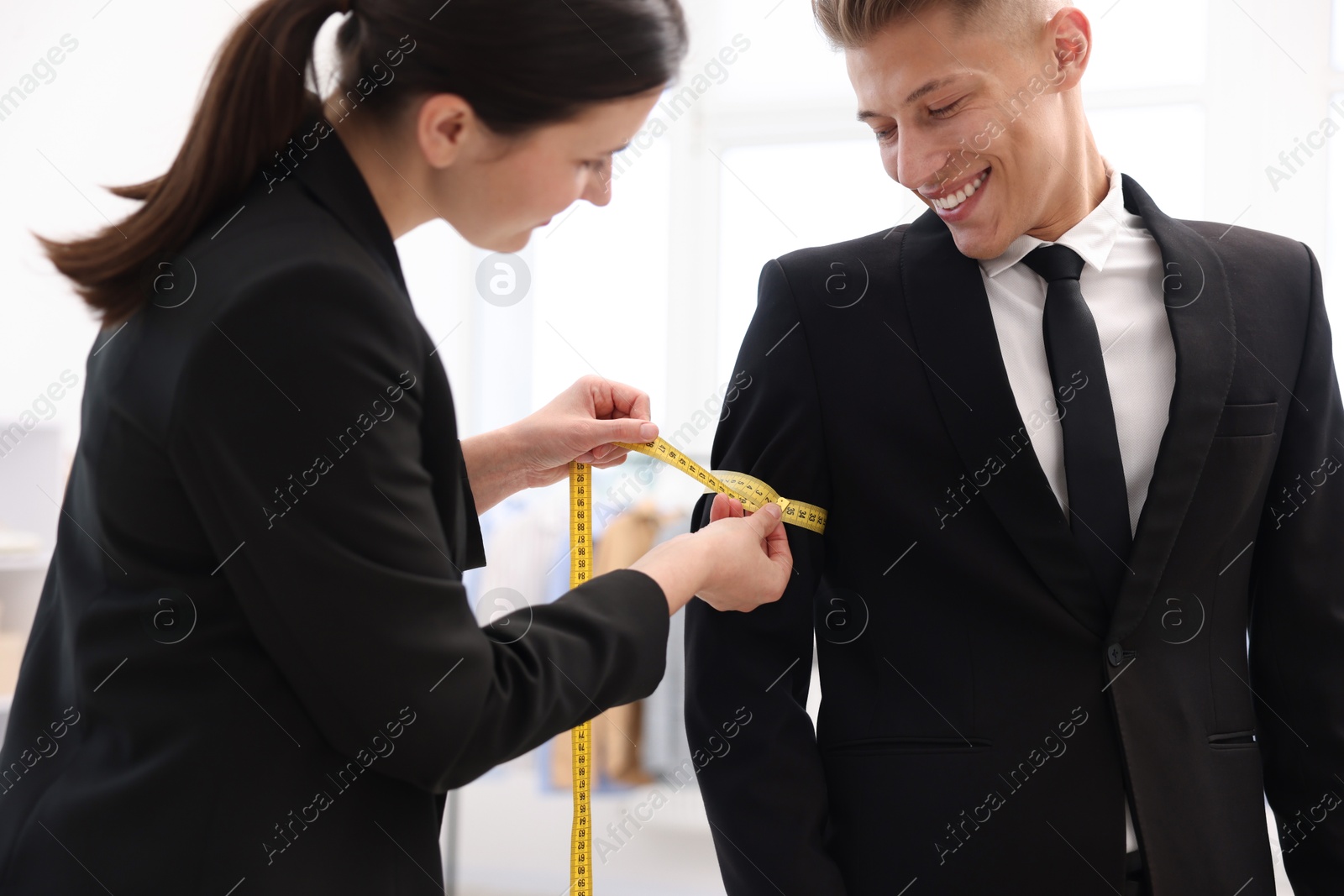 Tailor measuring jacket on man in atelier Photo of Tailor measuring jacket on man in atelier