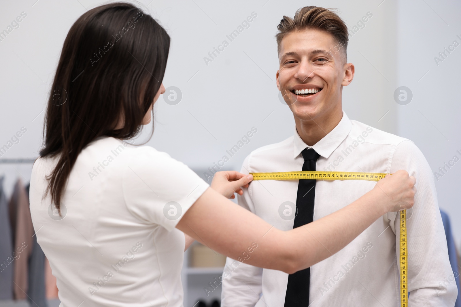 Tailor measuring man's chest with tape in atelier Photo of Tailor measuring man's chest with tape in atelier