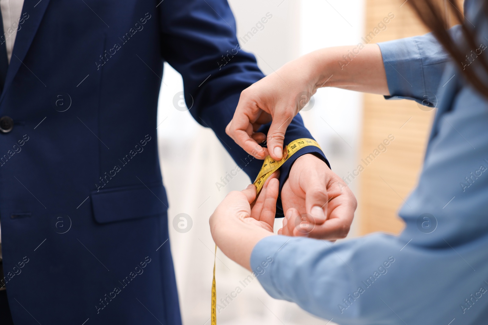 Tailor measuring jacket on man in atelier, closeup Photo of Tailor measuring jacket on man in atelier, closeup