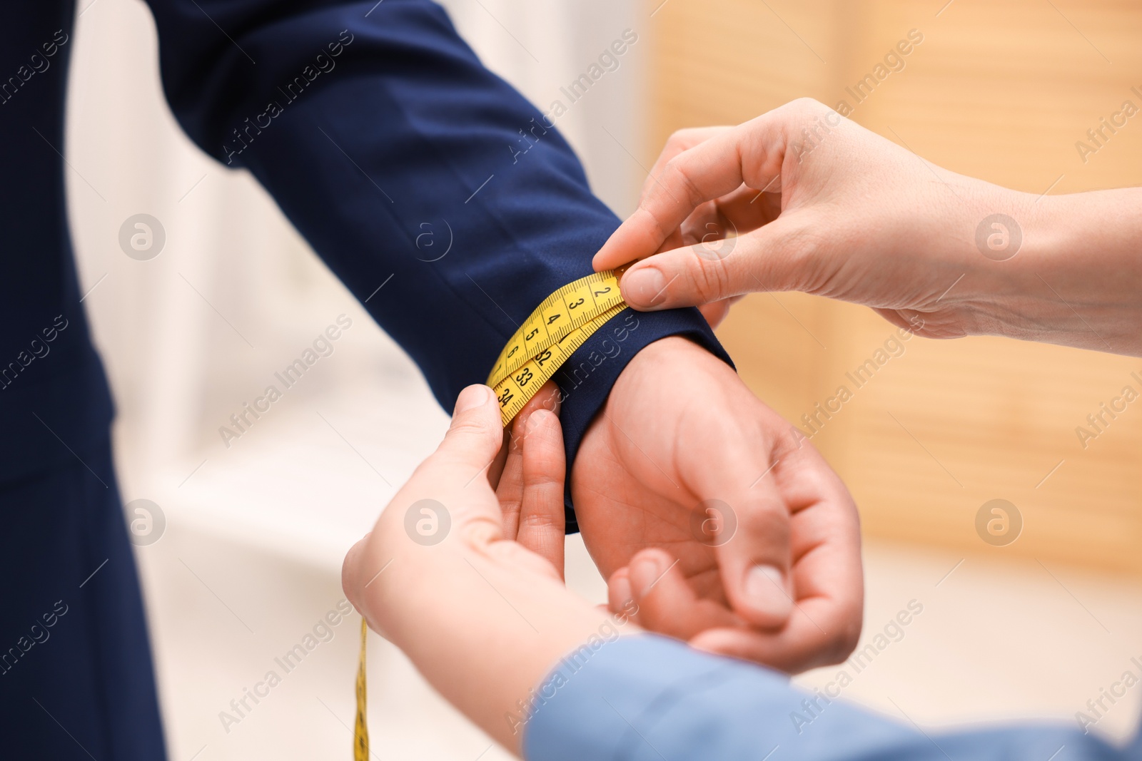 Tailor measuring jacket on man in atelier, closeup Photo of Tailor measuring jacket on man in atelier, closeup